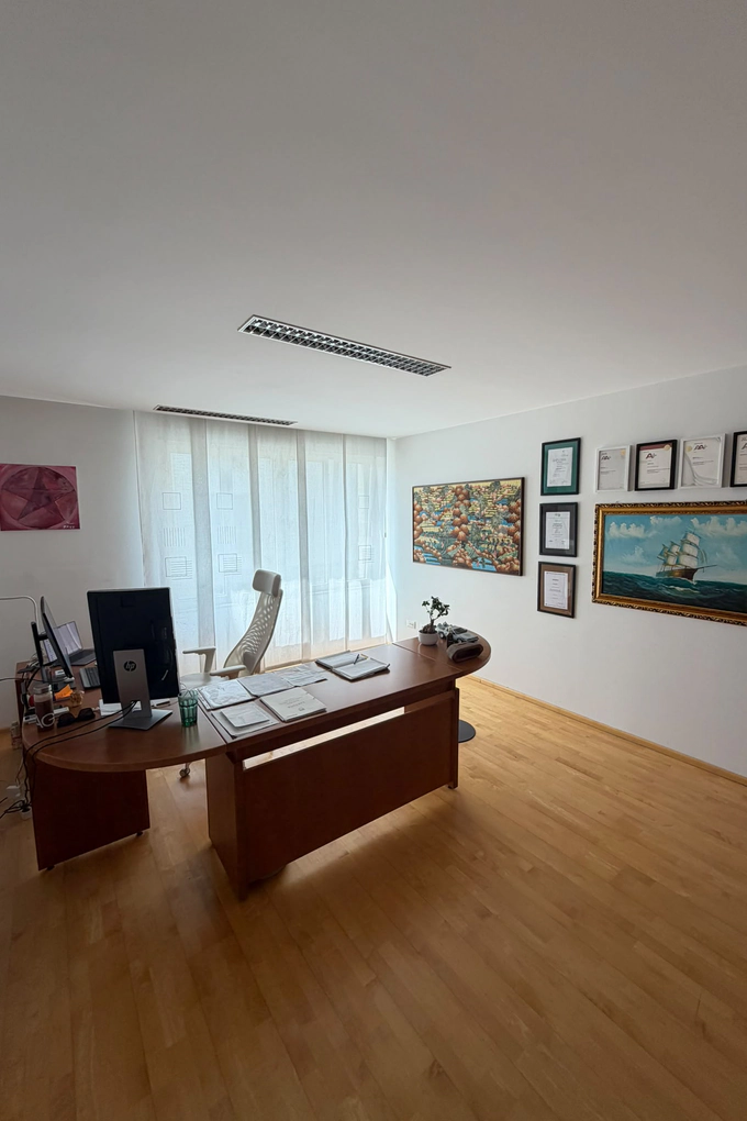 Un ufficio dello studio, con la scrivania e i riconoscimenti incorniciati alla parete